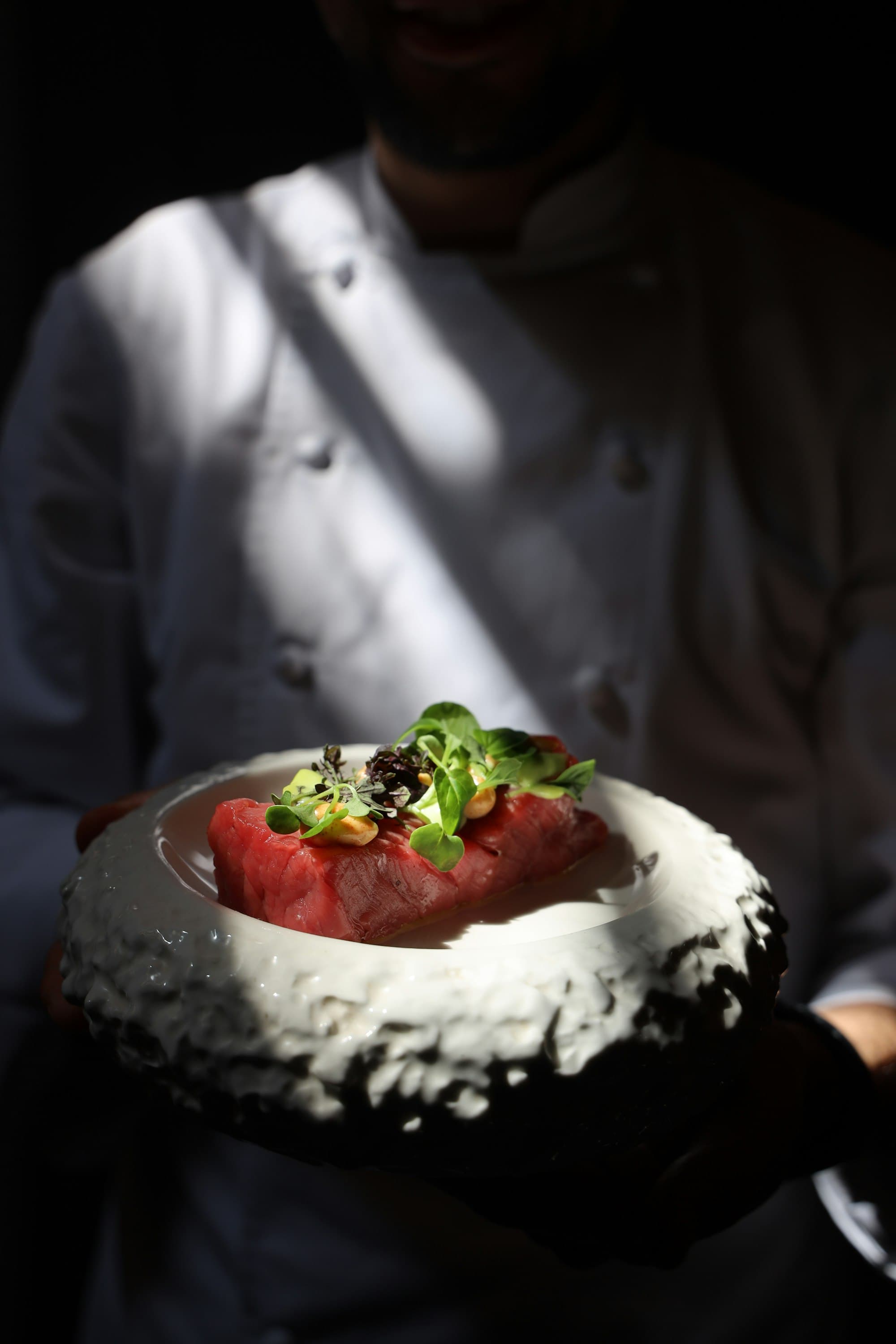 Assiette de thon cru et pousses fraîches dans une lumière rasante