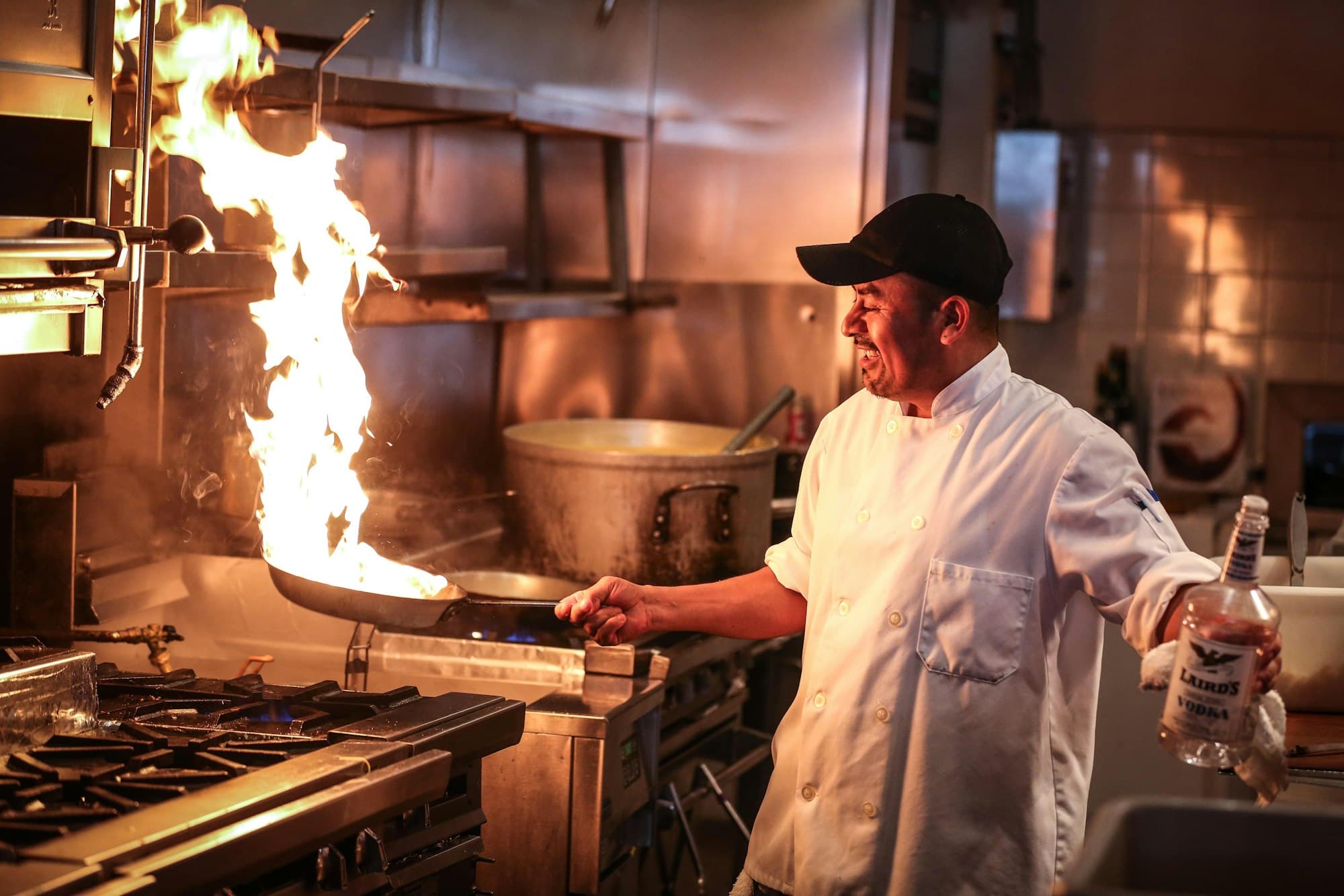 Un chef en cuisine devant une flambée sur le piano