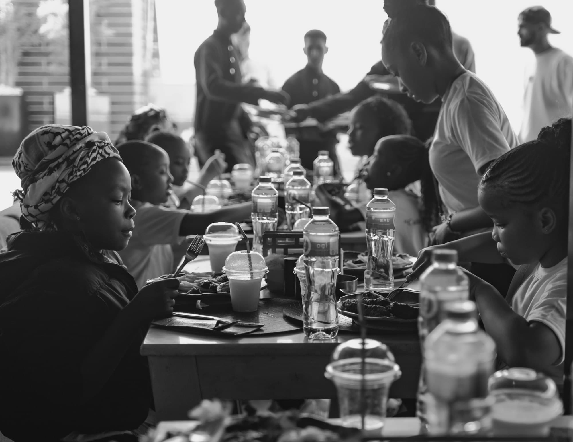 En noir et blanc, une grande tablée partageant un repas