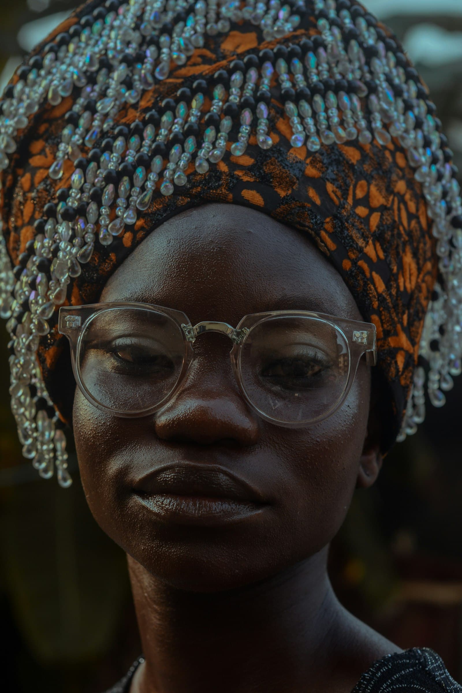 Portrait d'une femme portant une coiffe perlée et des lunettes